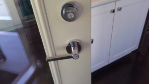 Professional locksmith hands using tools to rekey a residential deadbolt lock on a front door by Eagle's Locksmith.