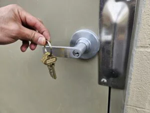 Eagle's Locksmith technician rekeying a commercial cylinder lock on an office door to restrict access and improve business security in Cincinnati.